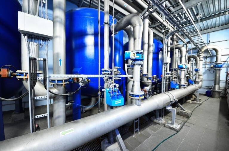 Large blue tanks in a industrial city water treatment boiler room. Wide angle perspective